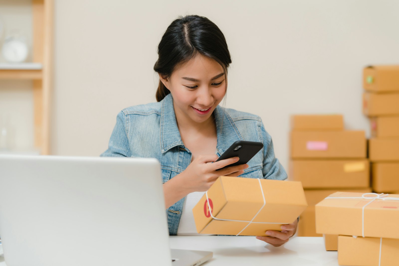 Ondernemer controleert een pakket naast laptop en verzenddozen