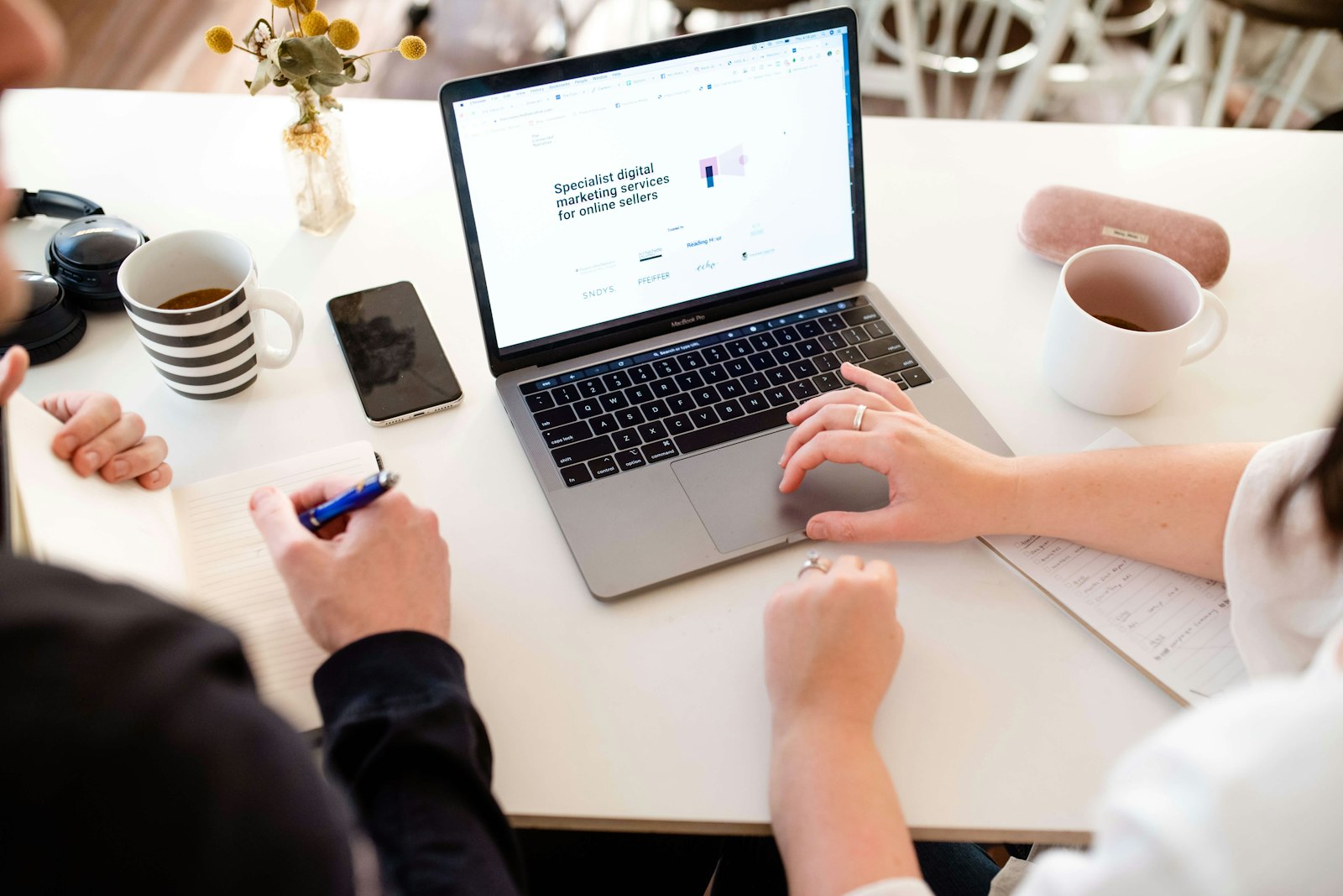 Ondernemer en webdesigner bespreken samen een website op een laptop